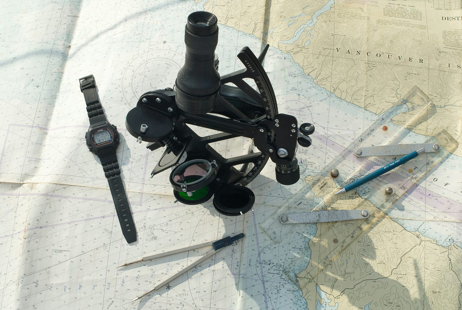 A sextant and dividers resting on a paper chart