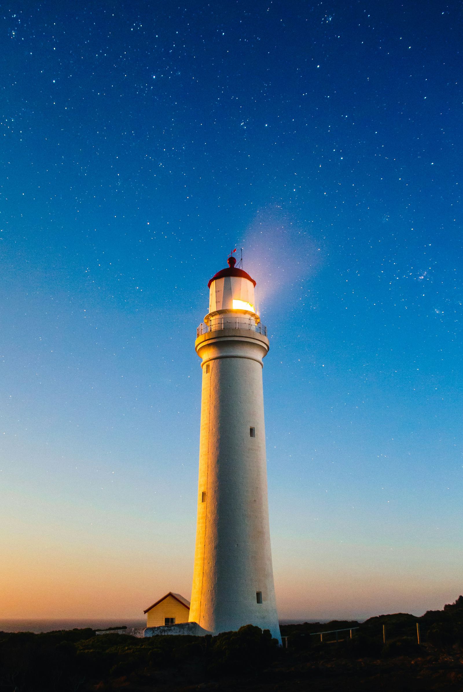 A white lighthouse standing against the sky